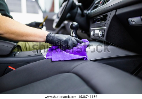 A man cleaning car interior, car\
detailing (or valeting) concept. Selective focus.\
