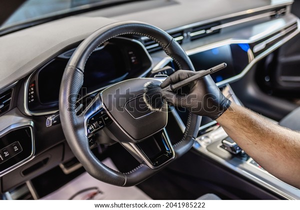 A man cleaning car interior, car\
detailing (or valeting) concept. Selective\
focus.	