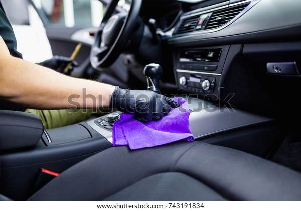 A man cleaning car interior, car\
detailing (or valeting) concept. Selective focus.\

