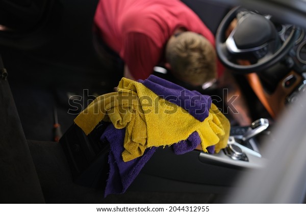 Man cleaning\
car interior at car wash\
closeup