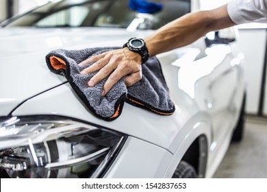 A man cleaning car with microfiber cloth, car detailing (or valeting) concept. Selective focus. - Shutterstock ID 1542837653