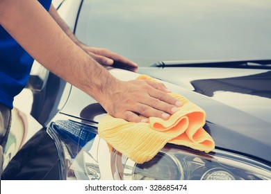 A man cleaning car with microfiber cloth, vintage tone image