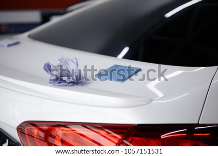 A man cleaning car with microfiber cloth, car detailing or valeting concept. Selective focus.