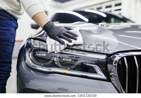 A man cleaning car with\
microfiber cloth, car detailing (or valeting) concept. Selective\
focus. 