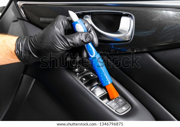 A man\
cleaning car with microfiber cloth and brush. Car detailing.\
Valeting concept. Selective focus. Cleaning car with brush. Worker\
cleaning. Car cleaning concept solution to\
clean.