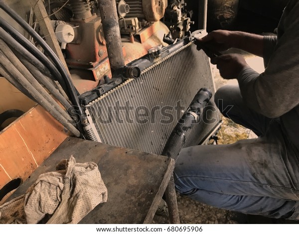 Man cleaning the car\
radiator with his hand in Sharjah Industrial area - Sharjah, UAE\
July 19, 2017
