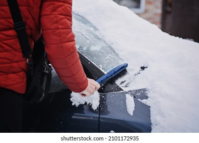 Man Cleaning Car From Snow And Ice With Brush And Scraper Tool During Snowfall. Winter Emergency. Weather-related Vehicle Emergencies. Automobile Covered With Snow