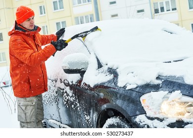 Man Cleaning Car From Snow In Winter