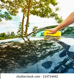 man cleaning the car in the sunny day