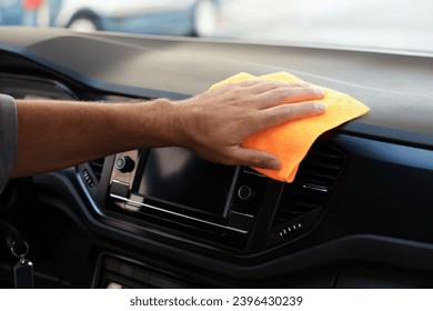 Man cleaning center console with rag in car, closeup - Powered by Shutterstock