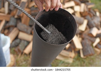 Man Cleaning Chimney Pipe Outside. Cleaning A Wood Burning Stove. Chimney Sweep Cleaning