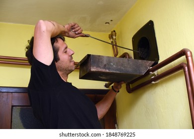 Man Cleaning Chimney Pipe Outside. Cleaning A Wood Burning Stove. Chimney Sweep Cleaning