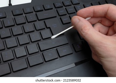 Man Cleaning A Dirty Keyboard With A Cotton Swab