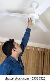 Man Cleaning Fan At Home