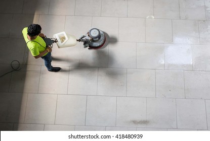 The Man Cleaning Floor With Machine.