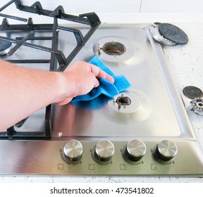 Man Cleaning A Gas Stove. 