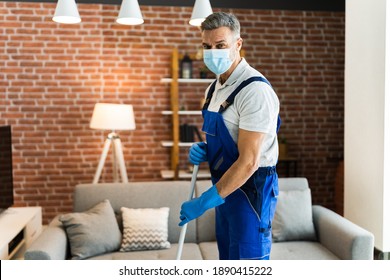 Man Cleaning The Hardwood Floor With Mop In Face Mask