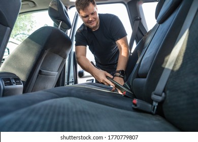 Man Cleaning Inside Car With Vacuum Cleaner