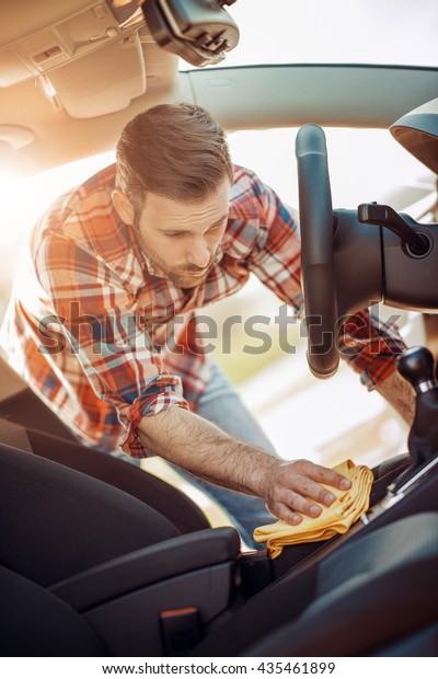 Man cleaning the\
interior of his car