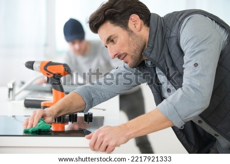 man cleaning a kitchen hob after installation