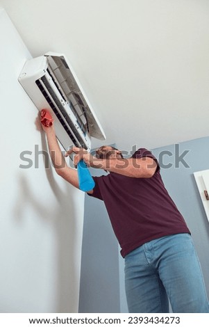 Man cleaning and maintaining air condition unit.