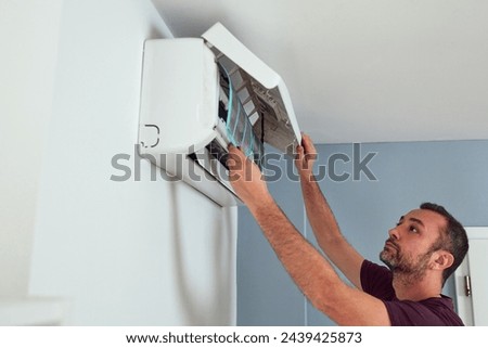 Man cleaning and maintaining air condition unit.