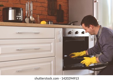 Man Cleaning Oven At Home