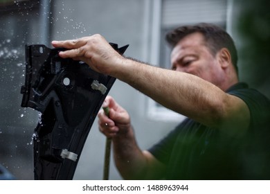 Man Cleaning Part Of Car With Wather In Back Yard