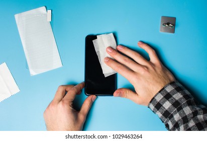 Man Cleaning Phone Screen To Apply Protective Tempered Glass