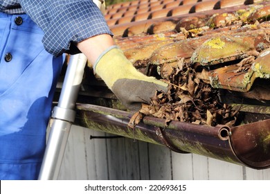 Man Cleaning A Rain Gutter In Close Up