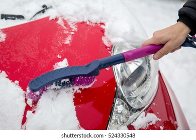 Man Cleaning Snow From Car With Brush.Removing Snow From Car