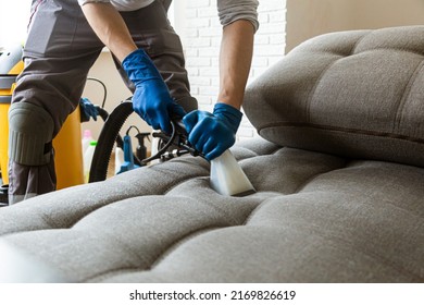 Man cleaning sofa chemical cleaning with professionally extraction method. Upholstered furniture. Early spring cleaning or regular clean up. - Shutterstock ID 2169826619
