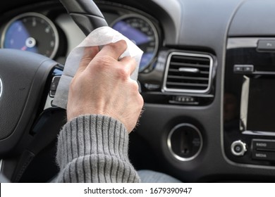 Man Cleaning Steering Wheel Of A Car Using Antivirus Antibacterial Wet Wipe (napkin) For Protect Himself From Bacteria And Virus. 