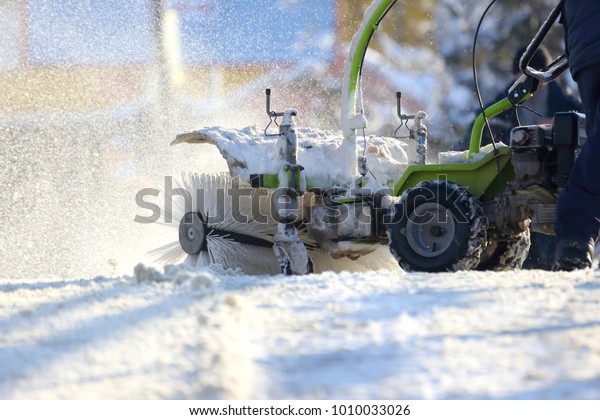 man cleaning the street from snow manual\
tractor special\
