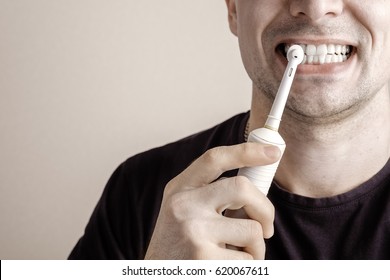 Man Cleaning Teeth With Electric Toothbrush Closeup