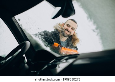 Man Cleaning Window Car From Snow With Brush