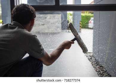 The man cleaning windows with a squeegee