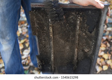 Man Cleaning Wood Burning Stove. Cleaning A Stove For Central Heating