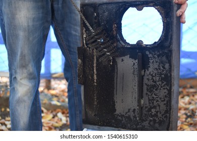 Man Cleaning Wood Burning Stove. Cleaning A Stove For Central Heating