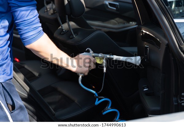 A man cleans car\
interior, car detailing 