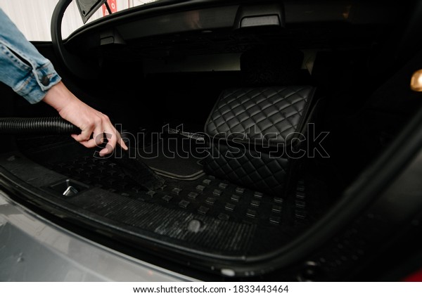 Man cleans car interior with vacuum\
cleaner.Cleaning a car using a vacuum\
cleaner
