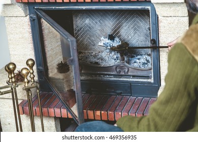 A Man Cleans The Fireplace. Taken Out Of The Fire A Long-handled Shovel With Ash
