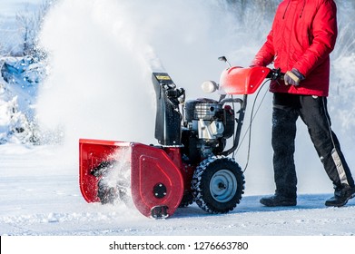 A man cleans the ice on a pond with a snowblower - Powered by Shutterstock