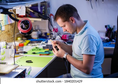 Man Cleans A Laptop With A Special Tool From Dust. Repair And Maintenance Of Laptops And PCs Advertising Services For The Repair Of Electronics And Devices.