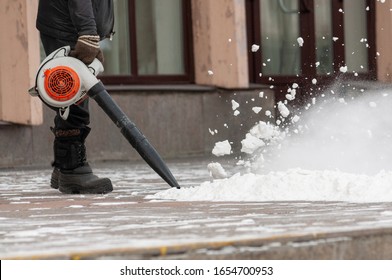 Man cleans pavement from snow with blower - Powered by Shutterstock