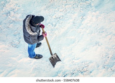 Man Cleans Snow Shovel, Top View. Toned