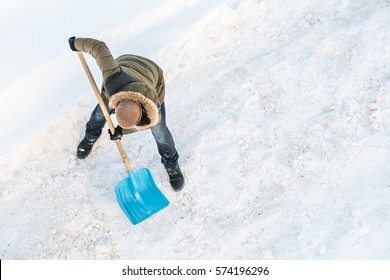 Man Cleans Snow Shovel, Top View