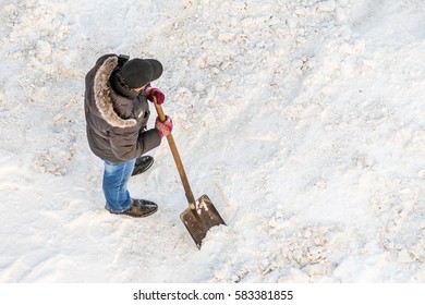 Man Cleans Snow Shovel, Top View