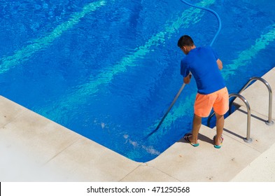 A Man Cleans The Swimming Pool. Summer Maintenance Service