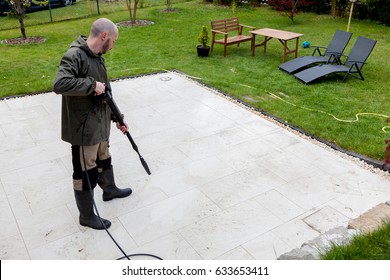 Man Cleans Terrace With High-pressure Water Blaster. 